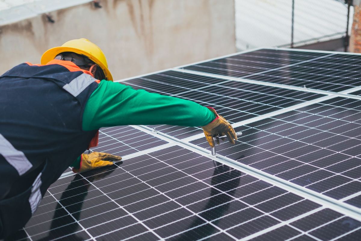 Installatore al lavoro su un tetto con pannelli fotovoltaici — impianto fotovoltaico a Chiari